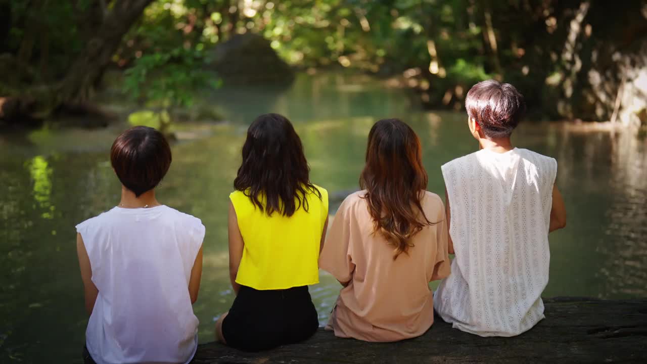 一群亚洲男人和女人一起在热带森林里放松。视频素材