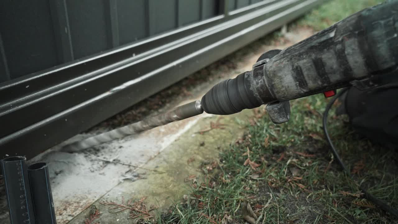 建筑工用锤子在墙上钻一个洞。冲击钻射孔器打孔特写视频素材