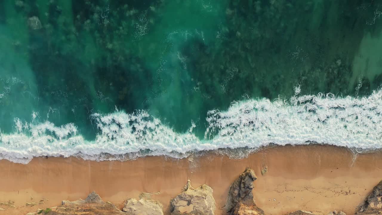 强大的海浪和白色的泡沫。空中俯瞰的沙滩和海洋冲浪在巴厘岛，靠近乌鲁瓦图视频素材