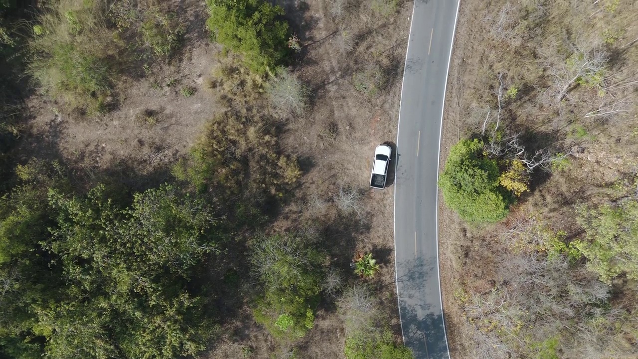 无人机拍摄鸟瞰风景，驾驶皮卡车在旱季偏僻的乡村道路上行驶视频素材