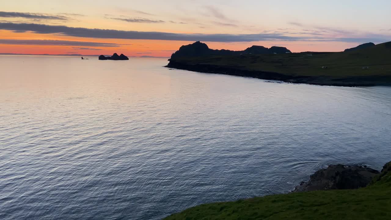 黄昏的色调在Heimaey海岸线，Stórhöfði，冰岛，平静的大海和轮廓的地形视频素材