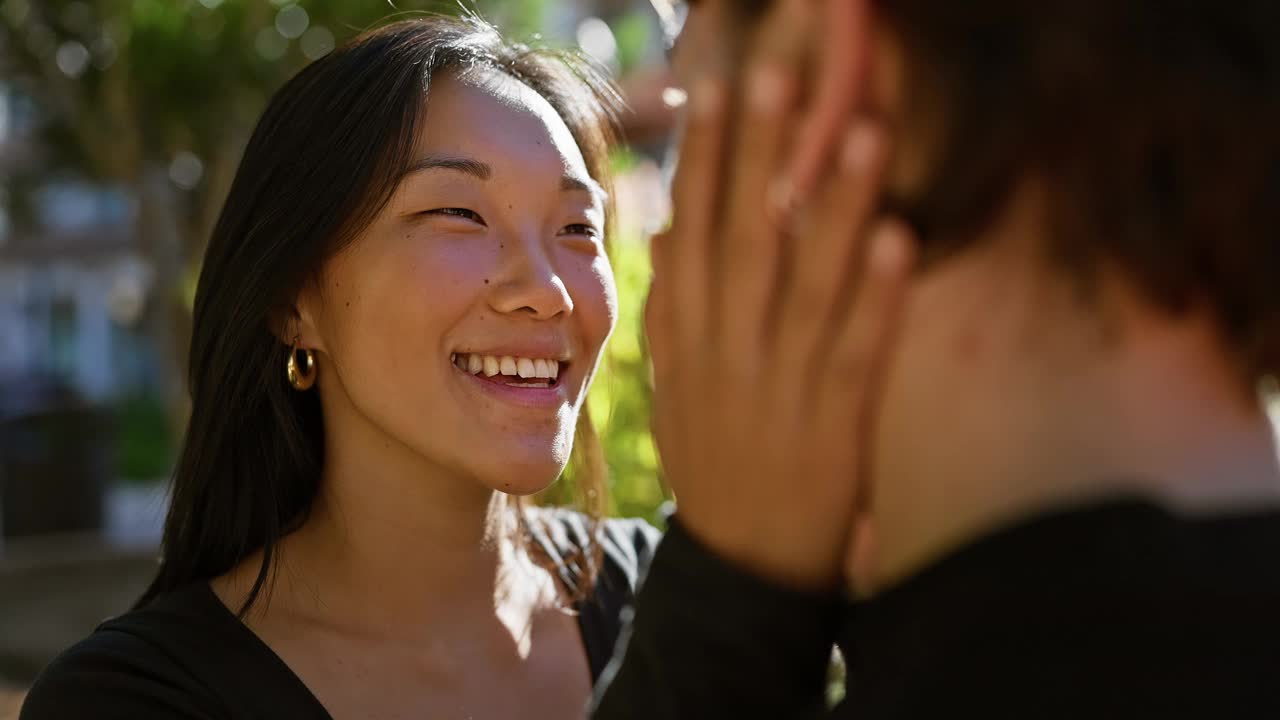 不同种族的夫妇在户外分享温柔的目光，用散景背景反映出感情和多样性。视频素材