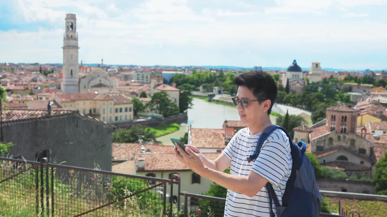 快乐的亚洲年轻游客用手机自拍，男游客在意大利度假旅行时拍照，录制视频。视频素材