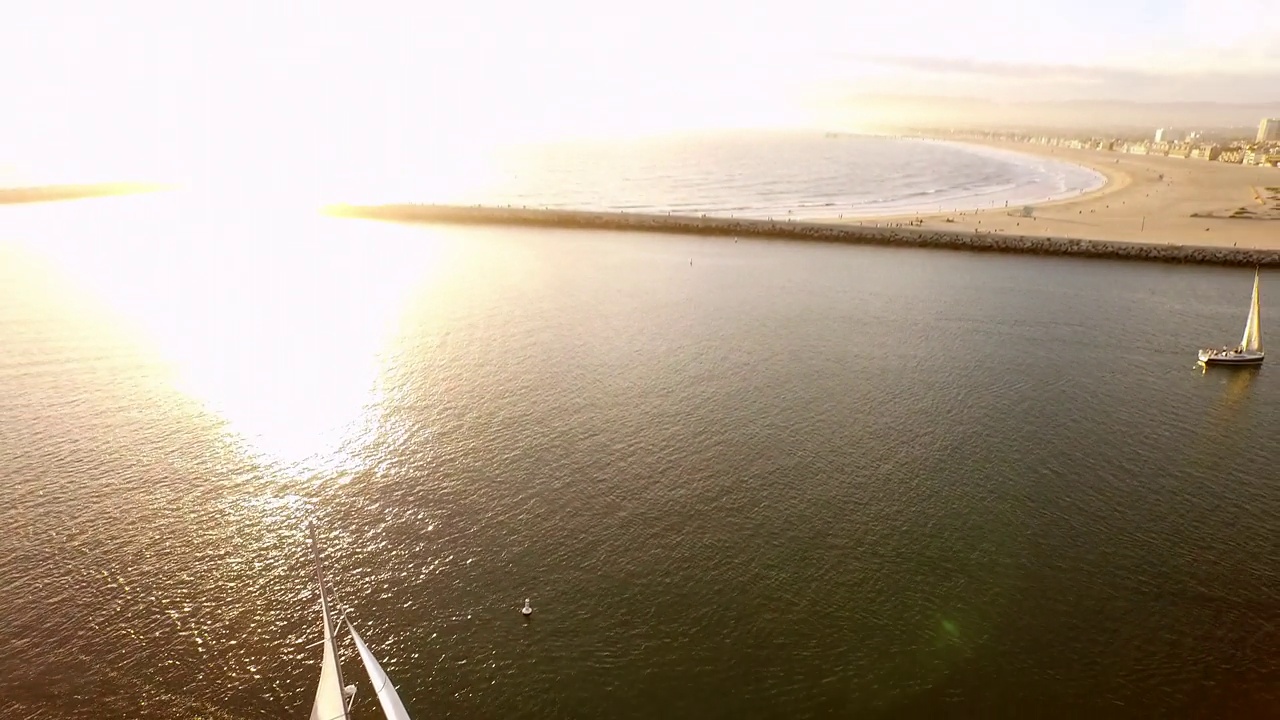 在宁静的日落期间漂浮在海上的游艇的空中倾斜风景，加利福尼亚州的雷伊码头视频素材