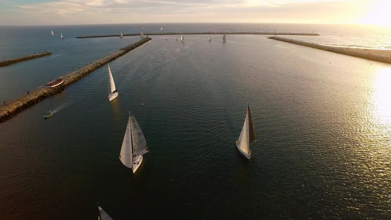 在日落时漂浮在海上的帆船的空中向后美景-加利福尼亚的雷伊码头视频素材