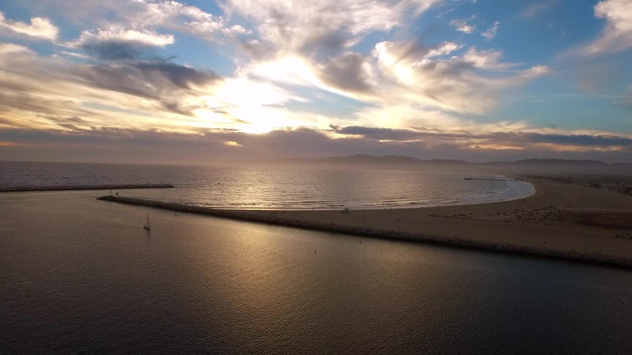 空中封锁美丽的游艇在涟漪的大海下戏剧性的云在日落期间-雷伊码头，加利福尼亚视频素材