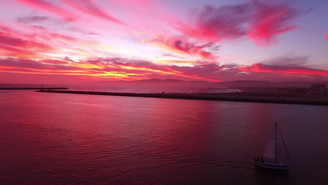 游艇在荡漾的大海中移动的空中风景，无人机在宁静的日落期间在码头上向后飞行-马里纳德尔雷伊，加利福尼亚视频素材