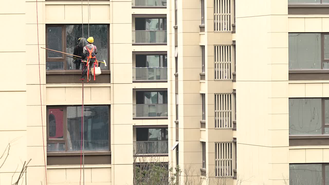 工人们在高层建筑外清洗玻璃视频下载