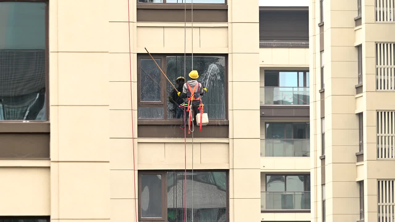 工人们在高层建筑外清洗玻璃视频下载