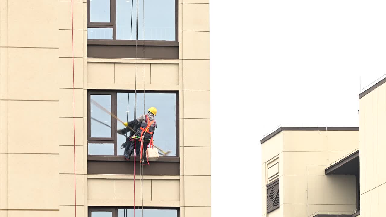 工人们在高层建筑外清洗玻璃视频下载