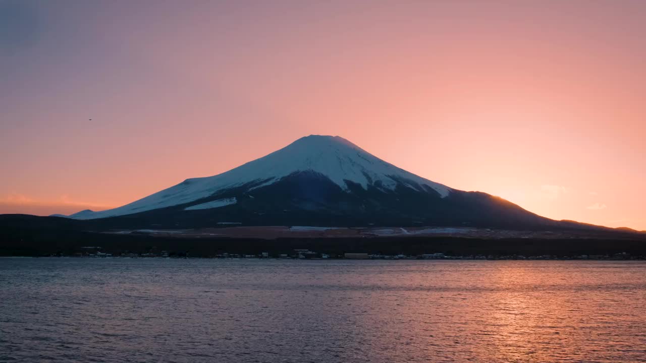 黄昏时分的富士山，落日映照在川口湖上，川口湖是游客和旅行者的地标和目的地。宁静夜晚的自然之美视频下载