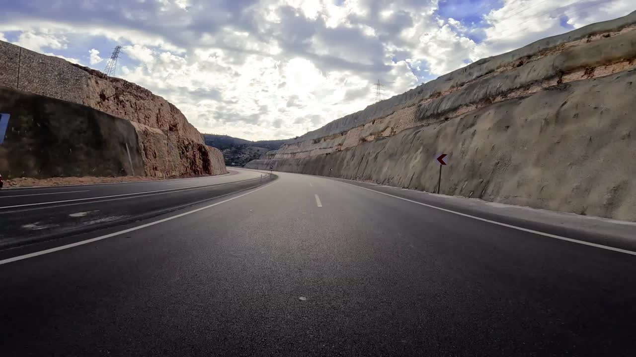 一辆汽车在山路上的视角，展示了曲折。视频捕捉了山路旅行的精髓，突出了自然景观。亲身体验在山路上驾驶视频素材