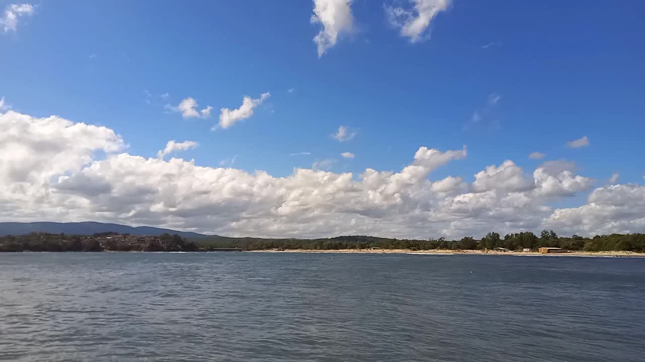 阳光明媚的夏日，风景如画的海景。沙滩和平静的大海的全景。酒店位于海滩附近，周围环绕着森林。在保加利亚黑海海岸度假，Kiten镇，南海滩视频素材