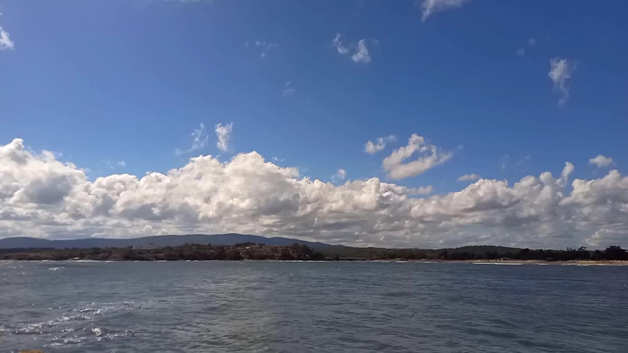 阳光明媚的夏日，风景如画的海景。沙滩和平静的大海的全景。酒店位于海滩附近，周围环绕着森林。在保加利亚黑海海岸度假，Kiten镇，南海滩视频下载