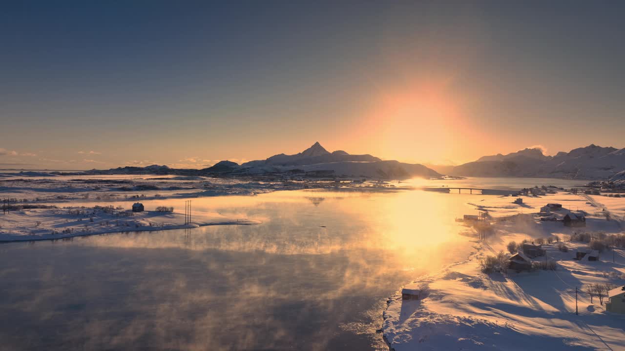 航拍日落的冬季景观，罗弗敦岛的海岸线与挪威雪山丘陵冻结的岩石海滩，挪威视频素材