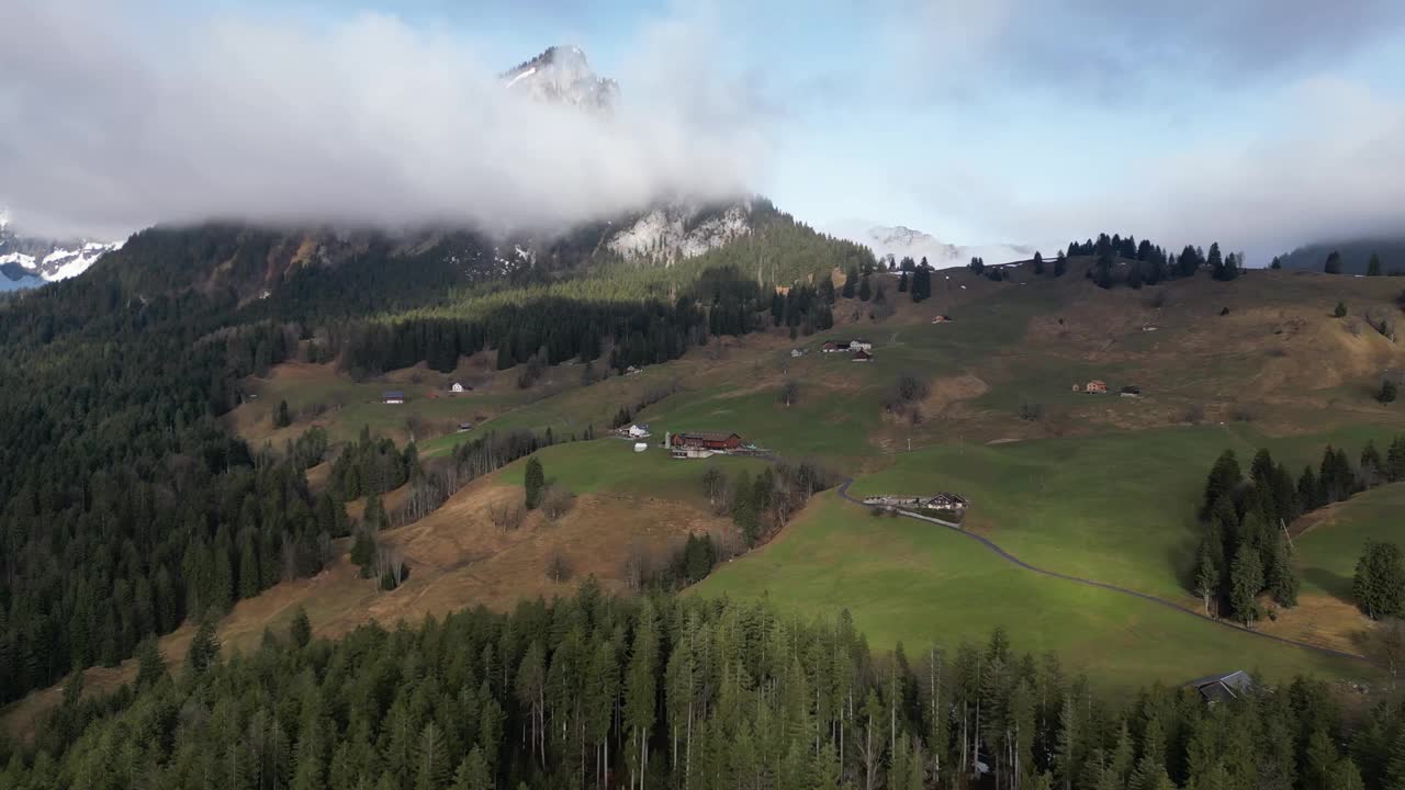 Obersee Glarus Näfels瑞士的向后飞行展示了阳光明媚的山腰上的家园视频素材