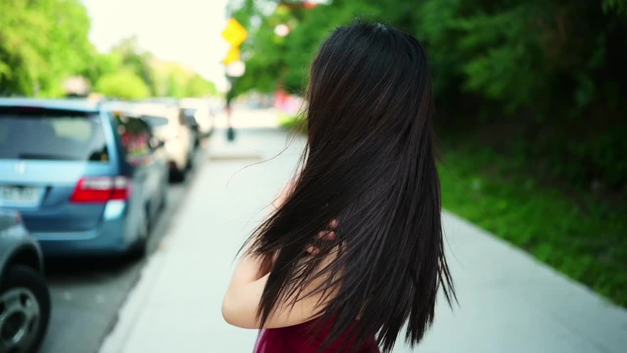 街头风格的户外肖像美丽年轻的中国亚洲快乐微笑的女人走在阳光明媚的夏日。有魅力的女人喜欢在停着的汽车前摆姿势。大城市生活理念。视频下载