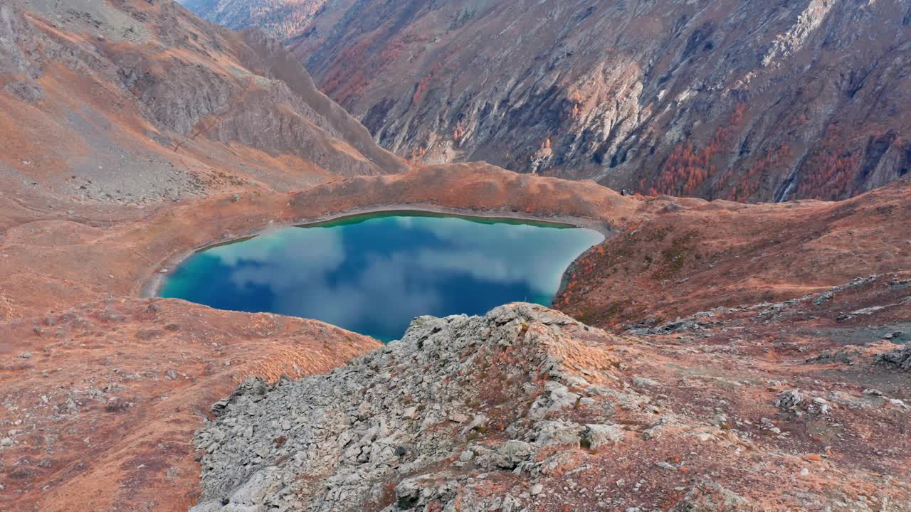 山湖坐落在秋日的山谷中，水中倒映着鲜艳的色彩，景色宁静视频素材