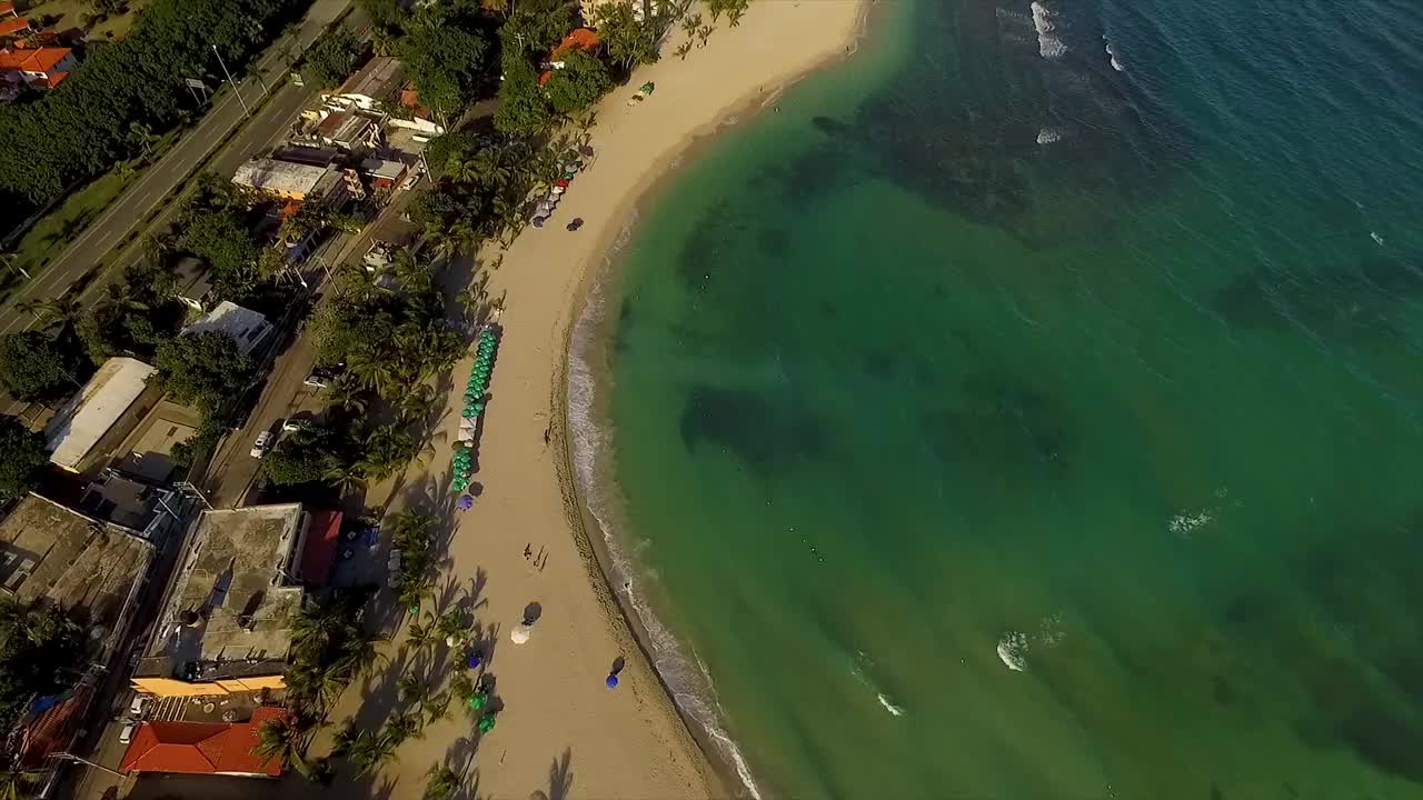 迈阿密海滩，清澈碧绿的海水和日光浴者，充满活力的遮阳伞点缀在沙滩上，鸟瞰图，美国视频素材