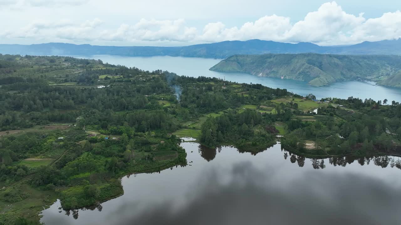 迷雾笼罩的群山为背景，平静的湖水为前景视频素材