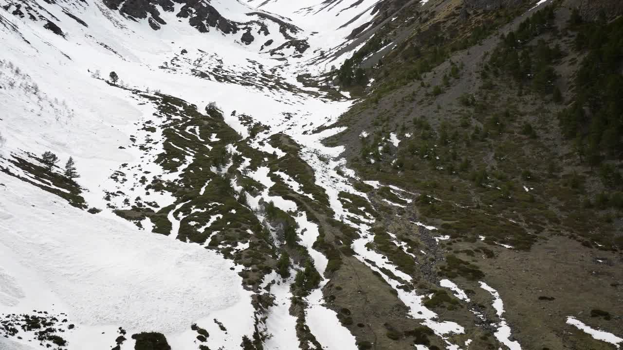 晚春自由骑行时，鸟瞰部分积雪覆盖的峡谷视频素材