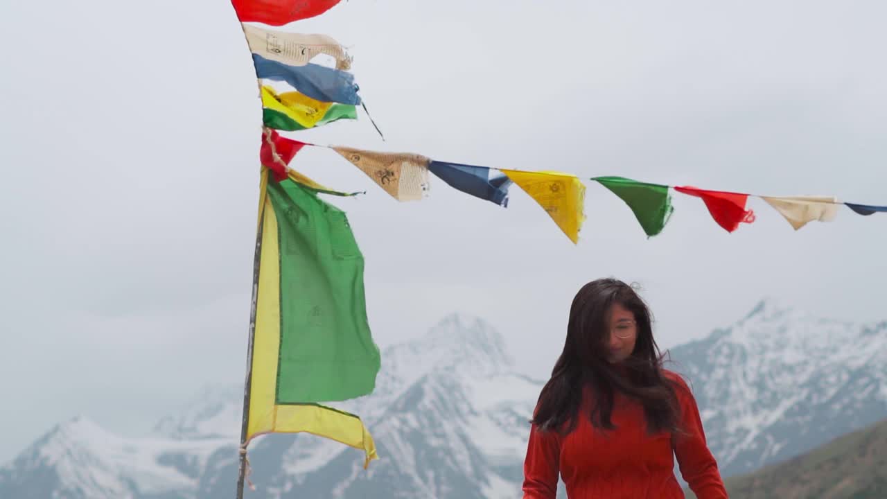 印度女孩走向镜头，背景是白雪覆盖的喜马拉雅山。山里的女孩。印度喜马偕尔邦拉胡尔夏季的恶劣天气。视频素材