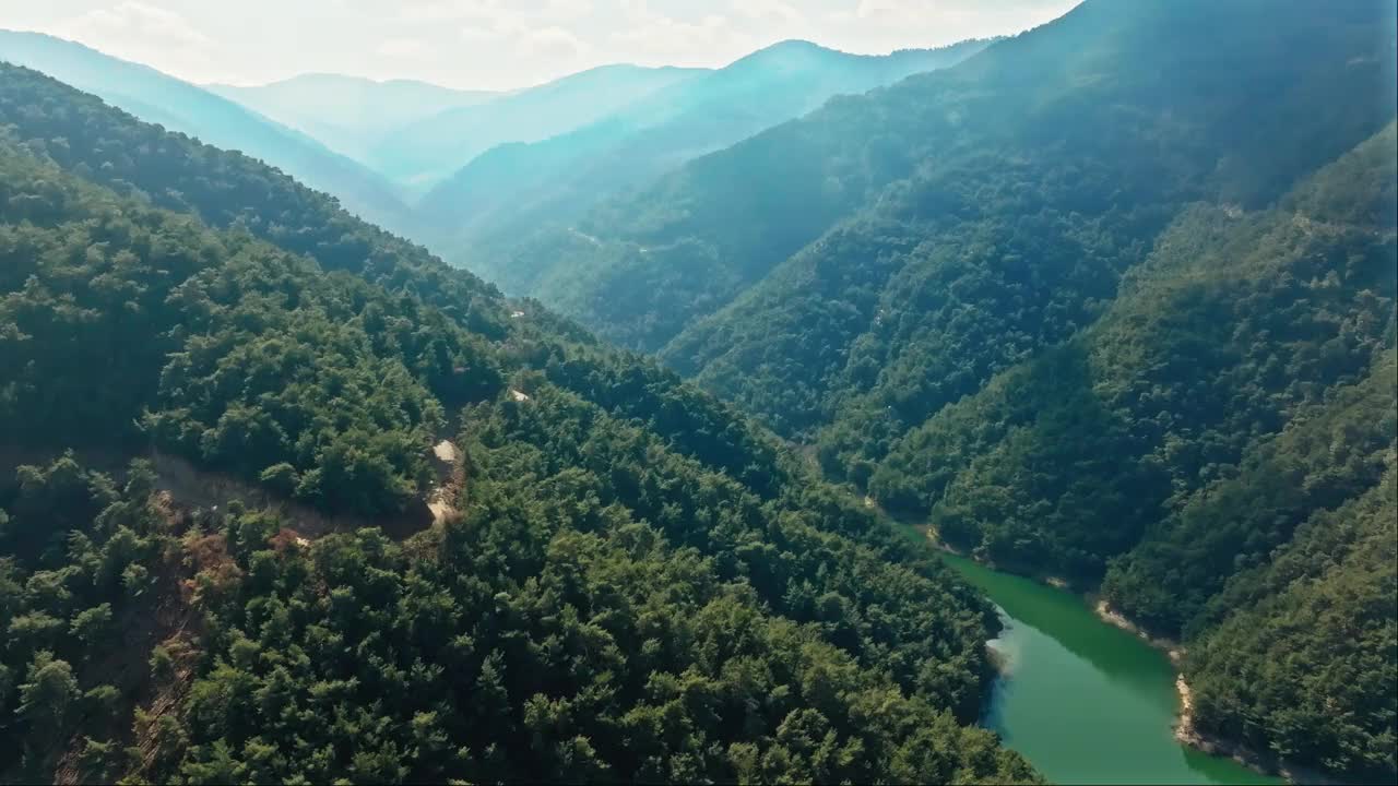 无人机拍摄的森林山脉之间的堰塞湖视频素材