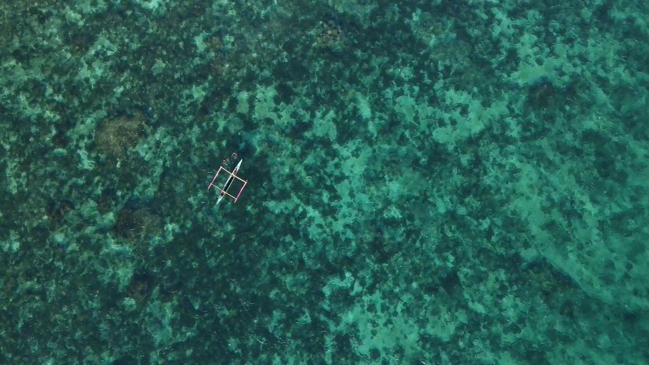 一个孤零零的竹筏漂浮在菲律宾薄荷岛碧绿的海水上，鸟瞰视频素材