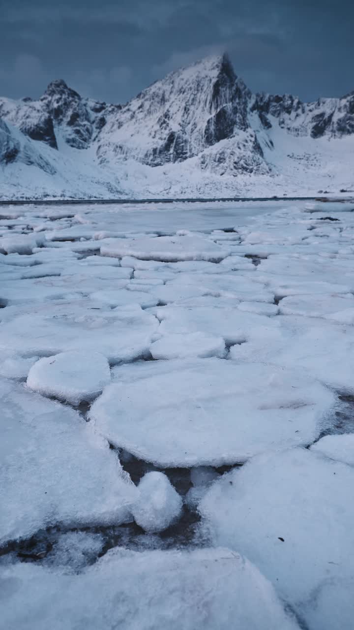 冬季海面景观垂直冻结海岸海滩岩石，峡湾山峰挪威罗弗敦群岛视频素材