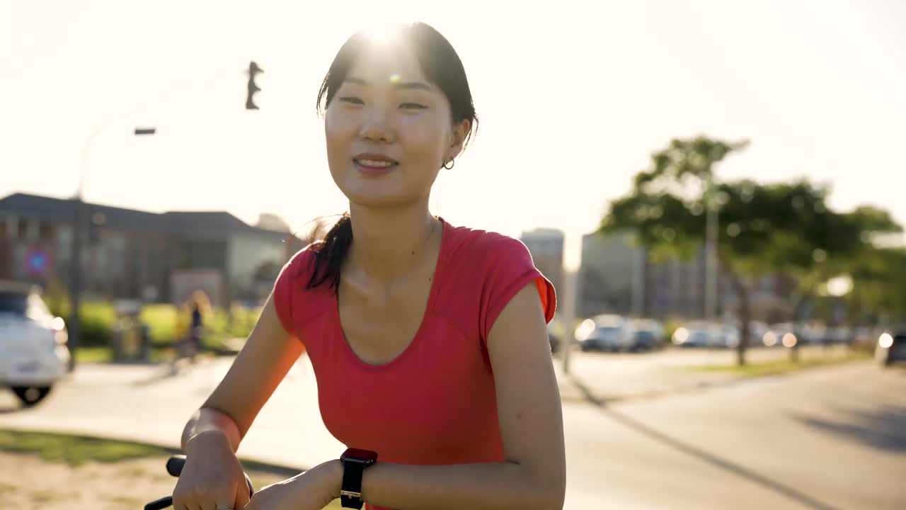 年轻的亚洲女子坐在自行车上享受清晨的阳光视频素材