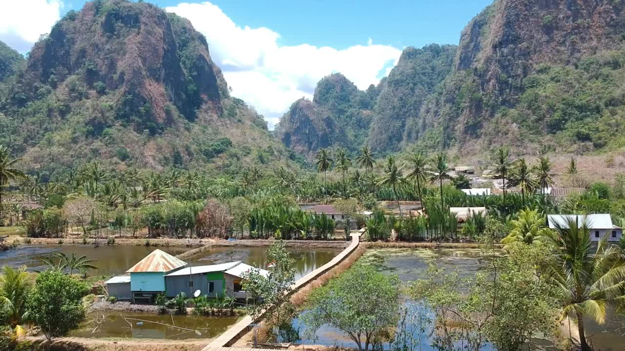 美丽的隐藏宝石Rammang Rammang村航拍与巨大的石灰岩悬崖和喀斯特山脉在印度尼西亚苏拉威西岛。视频素材