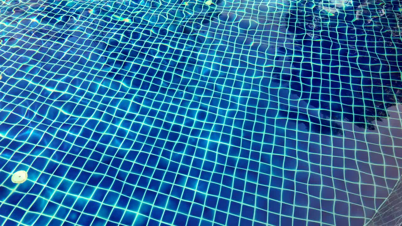 游泳池里的水在阳光的反射下泛起涟漪。夏天在游泳池。视频素材