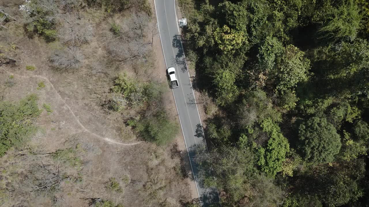 无人机拍摄鸟瞰风景，驾驶皮卡车在旱季偏僻的乡村道路上行驶视频素材