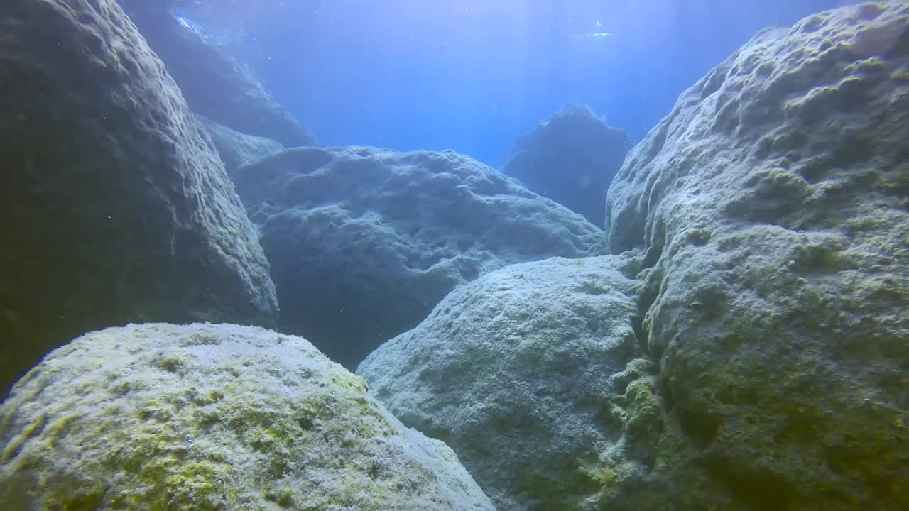 在明亮的阳光下，浅水里的巨石，慢动作视频素材