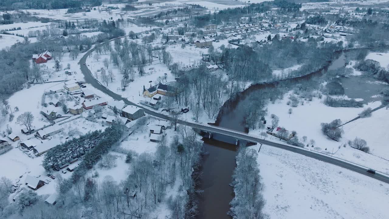 阿巴瓦河蜿蜒穿过白雪皑皑的Renda村(Kuldiga教区，拉脱维亚)，冬季景色，鸟瞰图视频素材