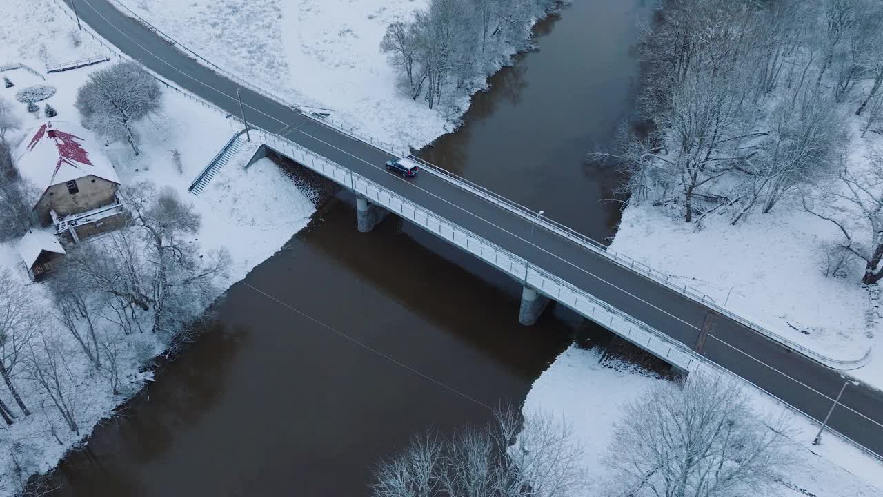 阿巴瓦河大桥附近的Renda村(Kuldiga教区，拉脱维亚)，积雪覆盖的景观，鸟瞰图，鸟瞰轨道拍摄视频素材