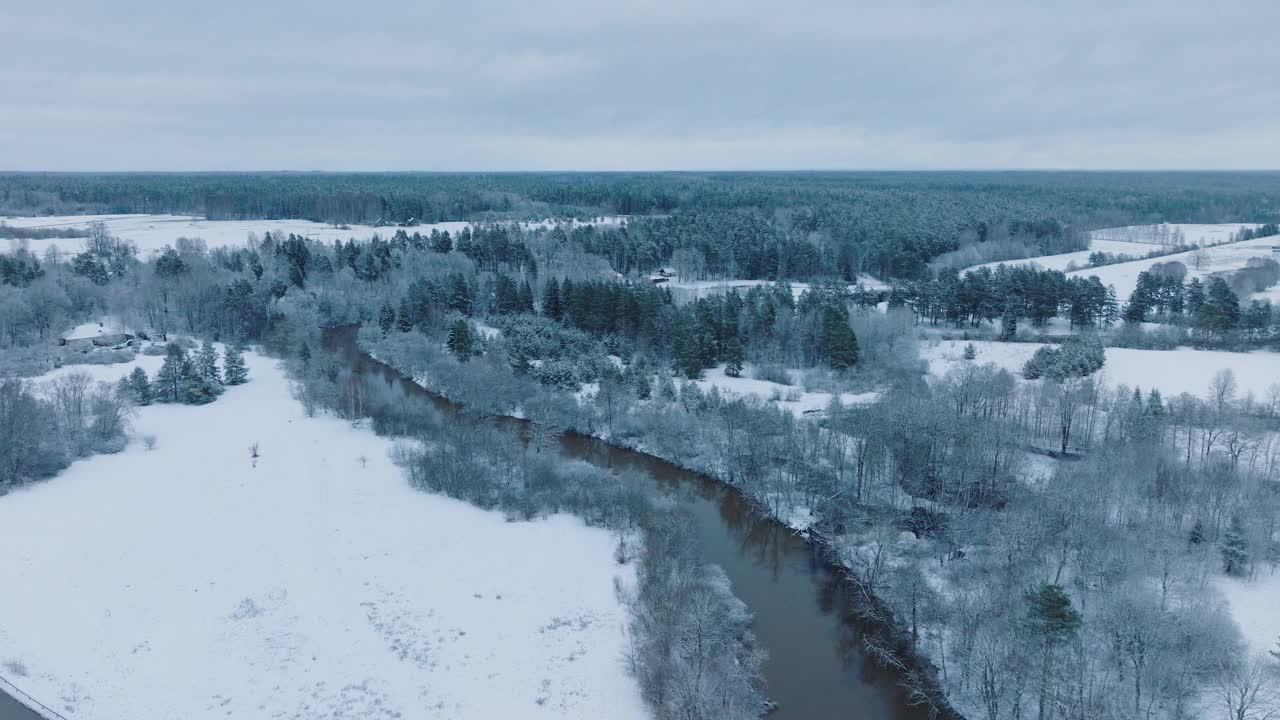 阿巴瓦河蜿蜒穿过伦达村附近的雪景(库尔迪加教区，拉脱维亚)，冬季背景，鸟瞰图，向后移动，倾斜向下视频素材