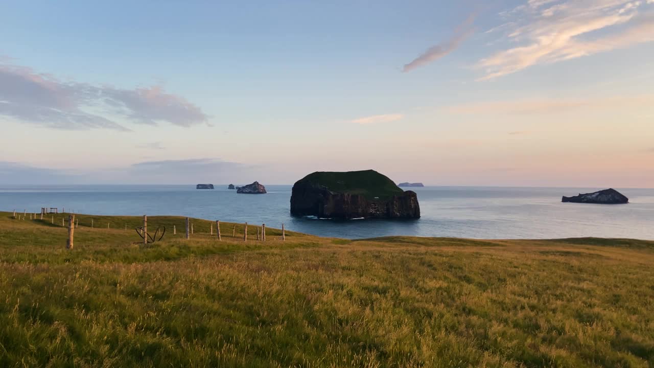 冰岛的黄金时段海景，宁静的大海和绿草如茵的前景，遥远的岛屿，宁静的心情视频素材