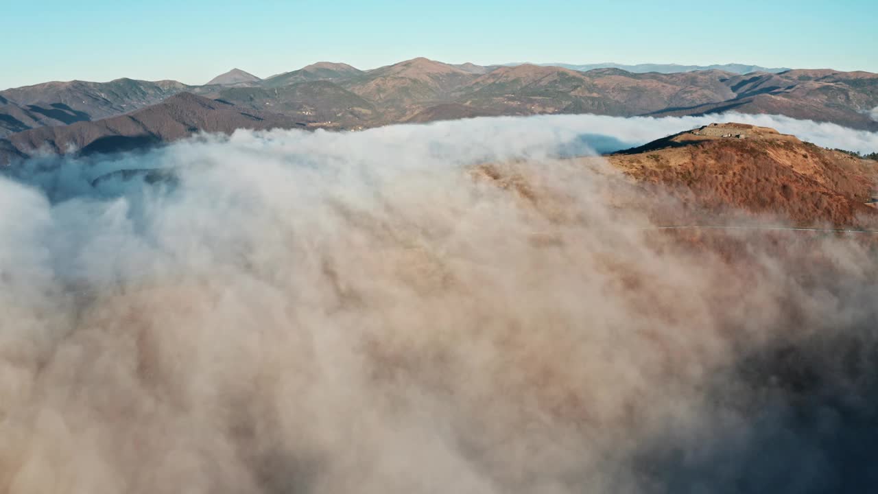 云雾笼罩的山峰在阳光下浮现，鸟瞰图视频素材