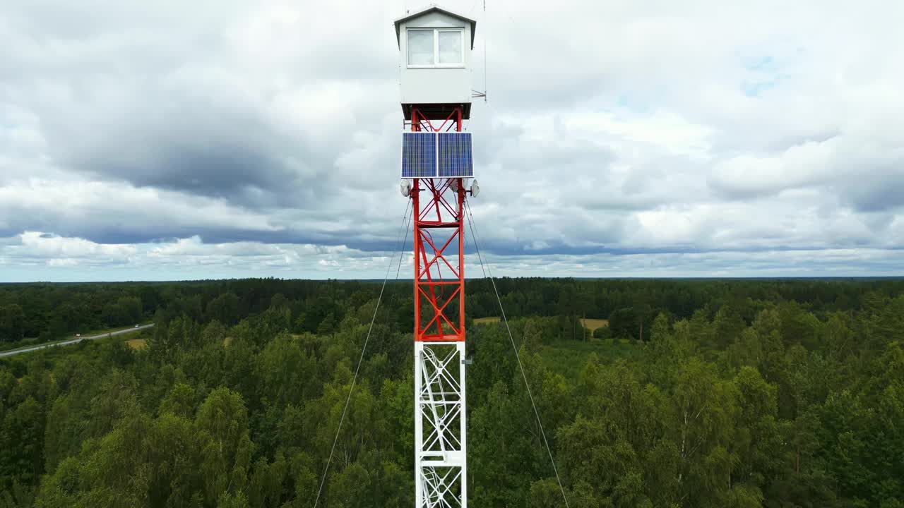 高空住宅:航拍照片捕捉到在晴朗的天空下，坐落在森林中的高塔上的一座高架房屋视频素材