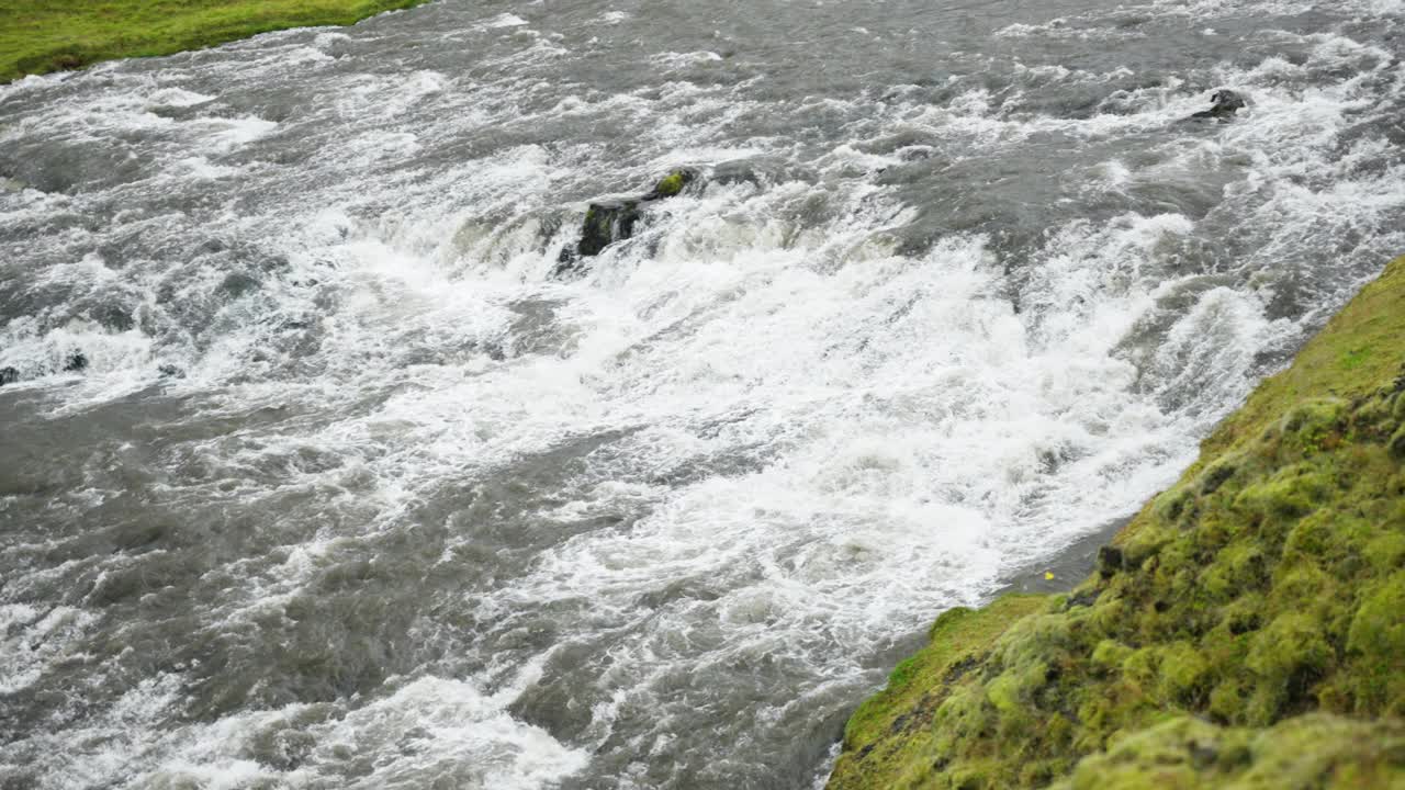 缓慢的平移镜头，巨大而宽阔的湍急的河流流淌着白色的泡沫。用辉煌的慢动作拍摄。冰岛,黄金。视频素材