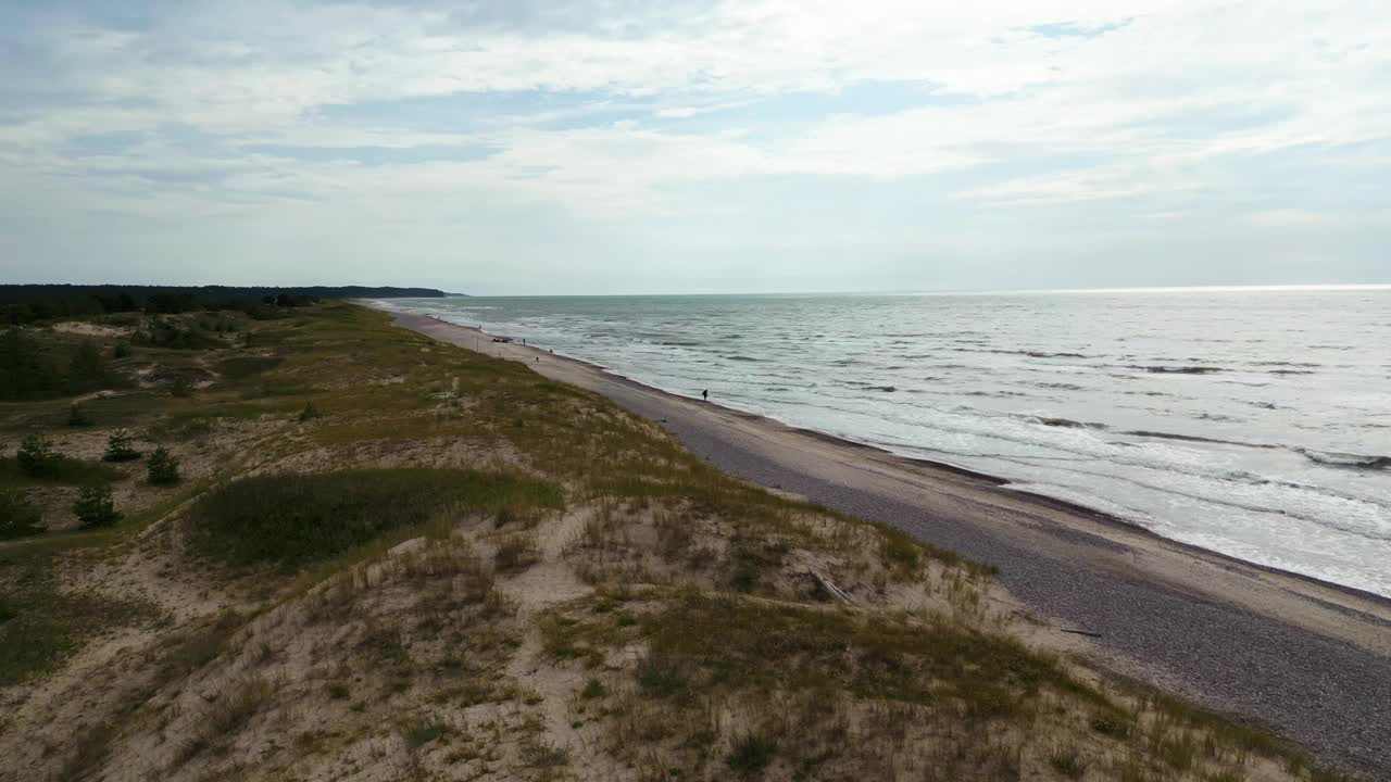 在多云的天空下，有一条通往大海的道路的海滩景观视频素材