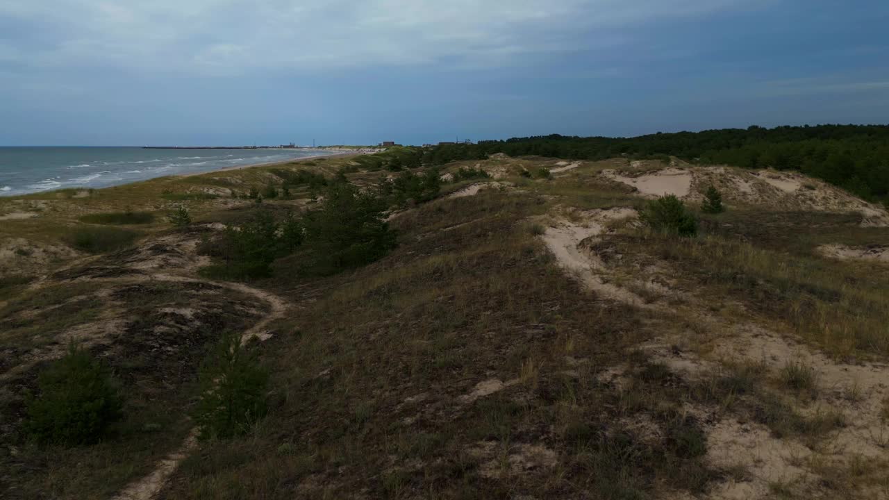 空中海洋通道:从上面看，一条道路蜿蜒穿过海滩景观，在多云的天空下引导着大海视频素材