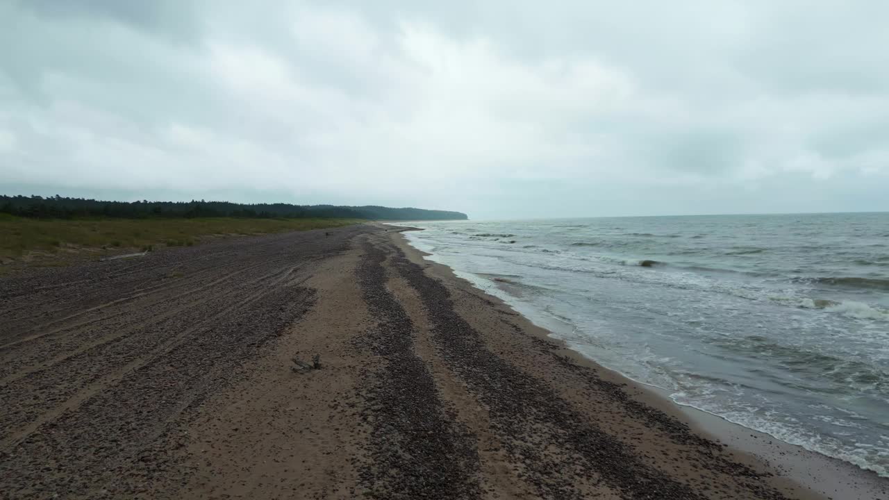 沿海上空的神秘:鸟瞰图捕捉到波罗的海海岸线的薄雾氛围，波浪在一个建立的镜头视频素材