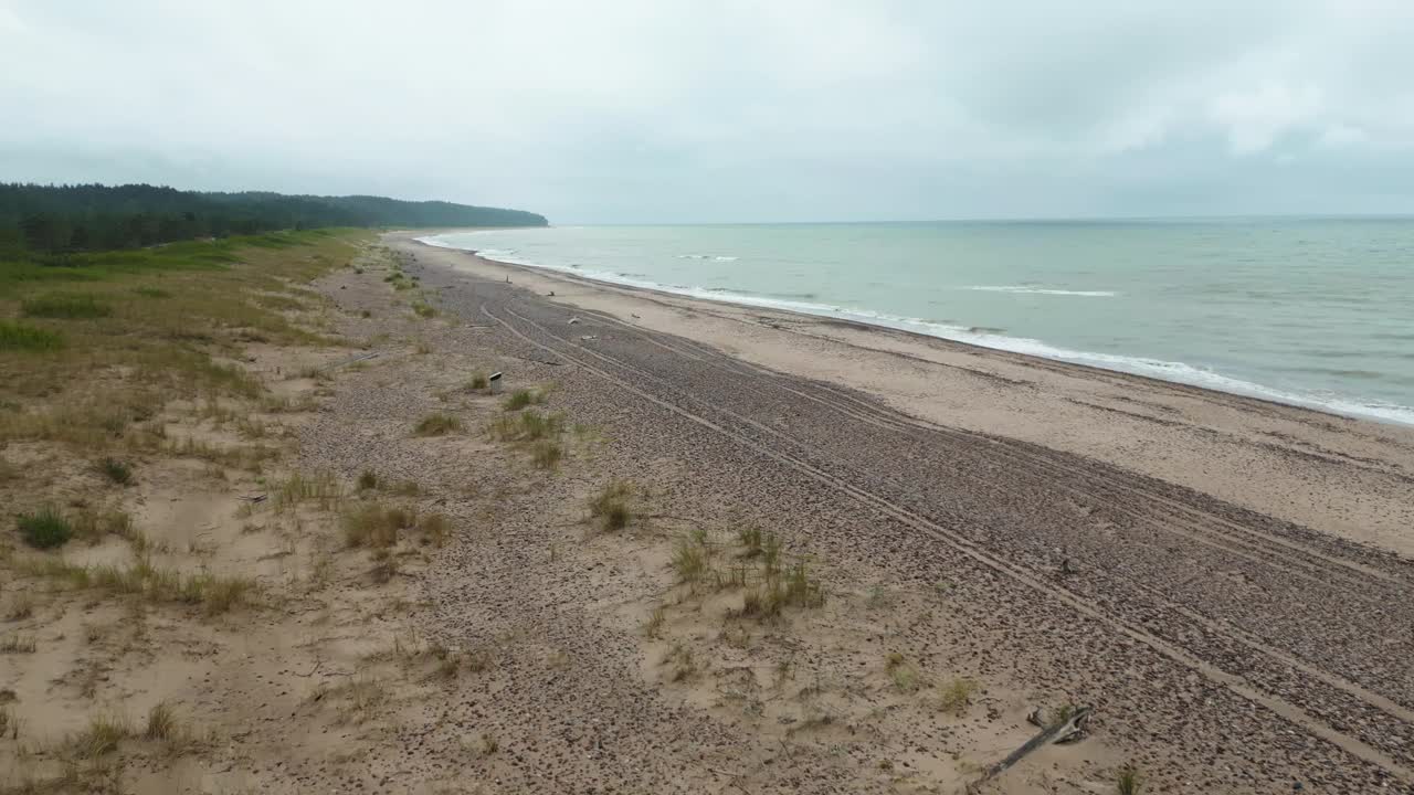 空中海岸的宁静:向天空的视角展示了雾蒙蒙的波罗的海海岸，在一个确定的镜头中强调了有节奏的波浪视频素材