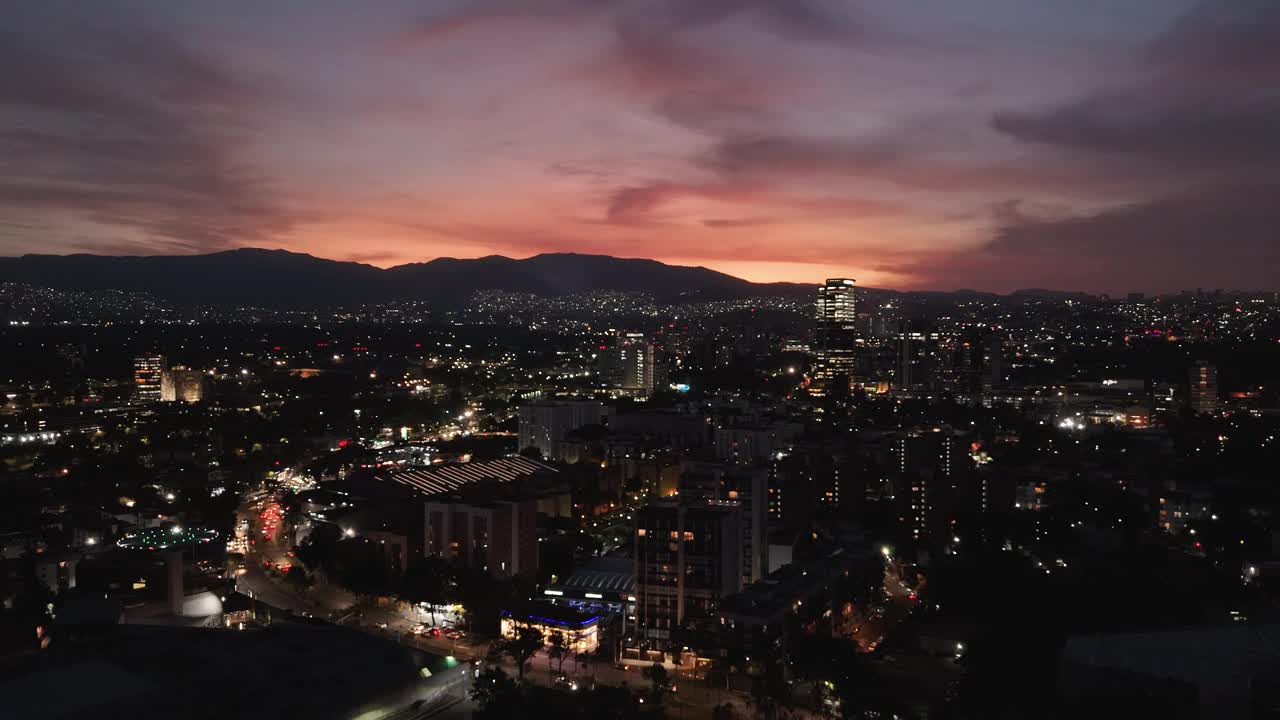 明亮的橙色色调照亮了墨西哥城南部的夜空视频素材