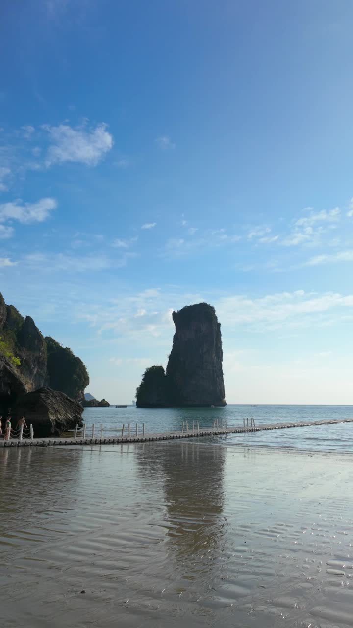 在海水和天空的映衬下，沙滩上矗立着一块巨大的岩石视频素材