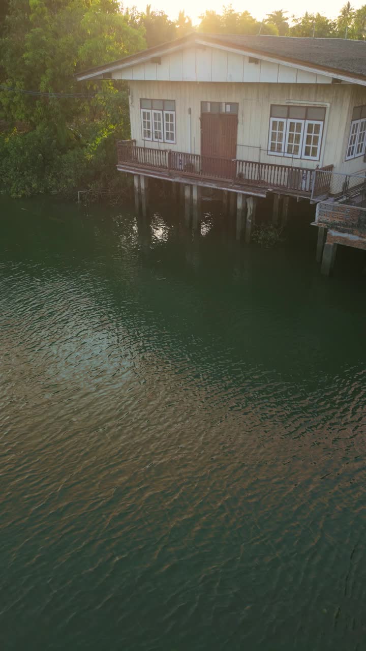 吊脚楼与水景，草地湖岸，和沥青水道下面视频素材