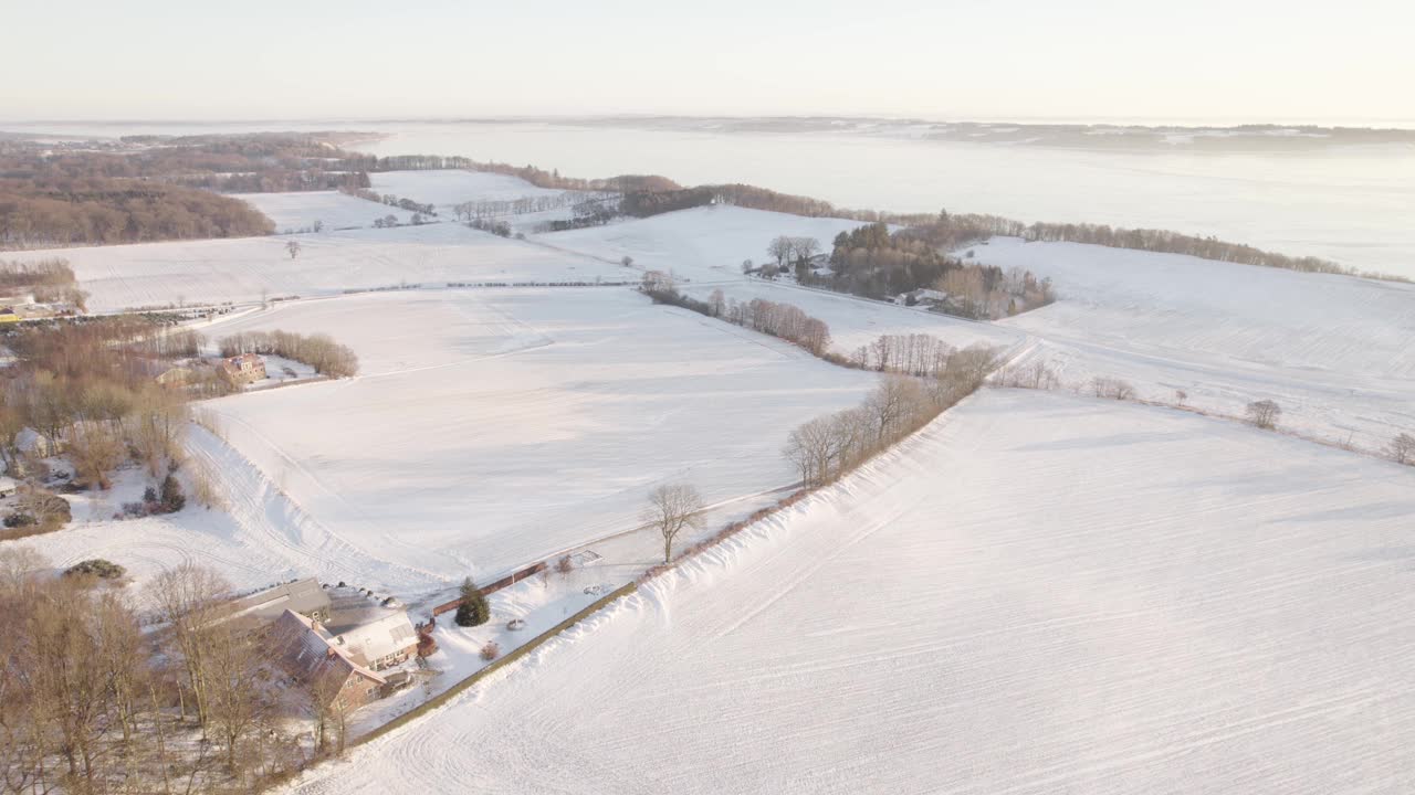 冬天日出时被雪覆盖的海岸农场。空中拍摄视频素材