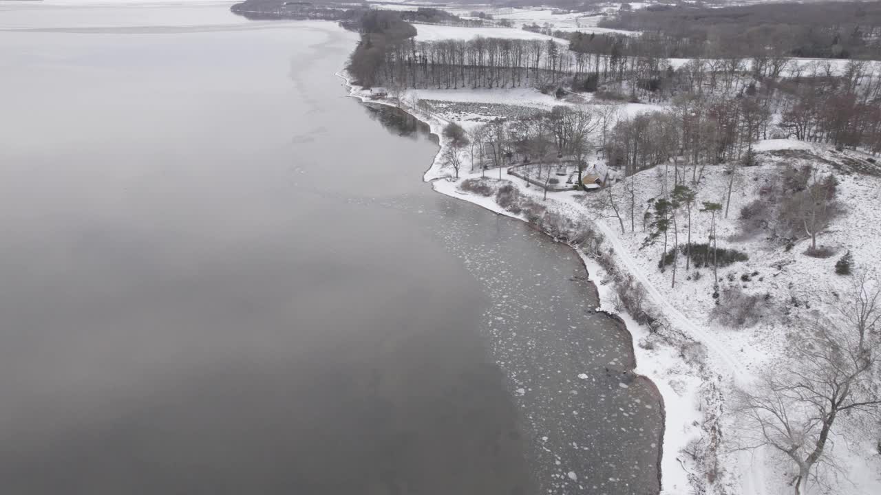 冬天，冰封的峡湾水和白雪皑皑的海岸。空中拍摄视频素材